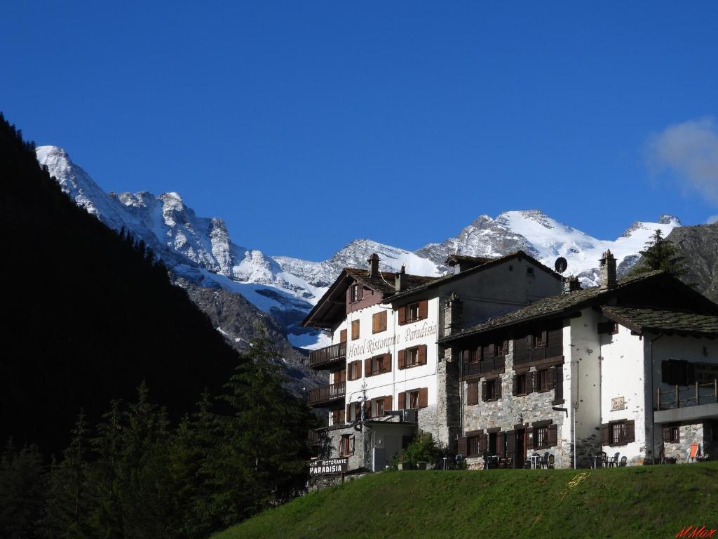 科涅Hotel Paradisia的山丘上的建筑,背景是山脉