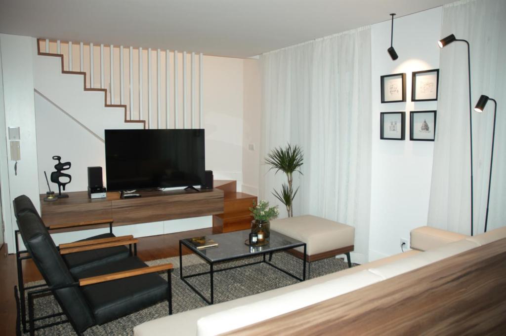 里斯本Timeless Charming - Belém的一间带电视和椅子的客厅