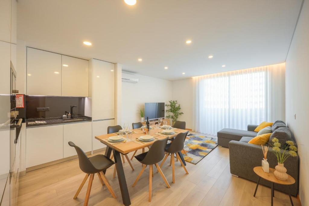 阿威罗Alameda 74 Luxury Apartment by Home Sweet Home Aveiro的厨房以及带桌椅的起居室。