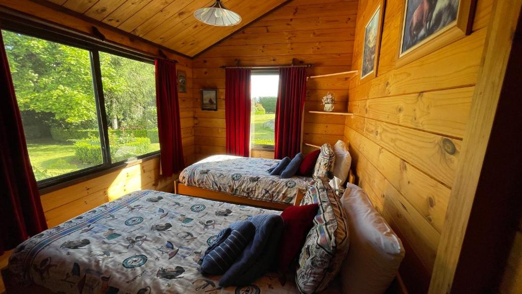 WaltonFantail Garden的小木屋内一间卧室,配有两张床