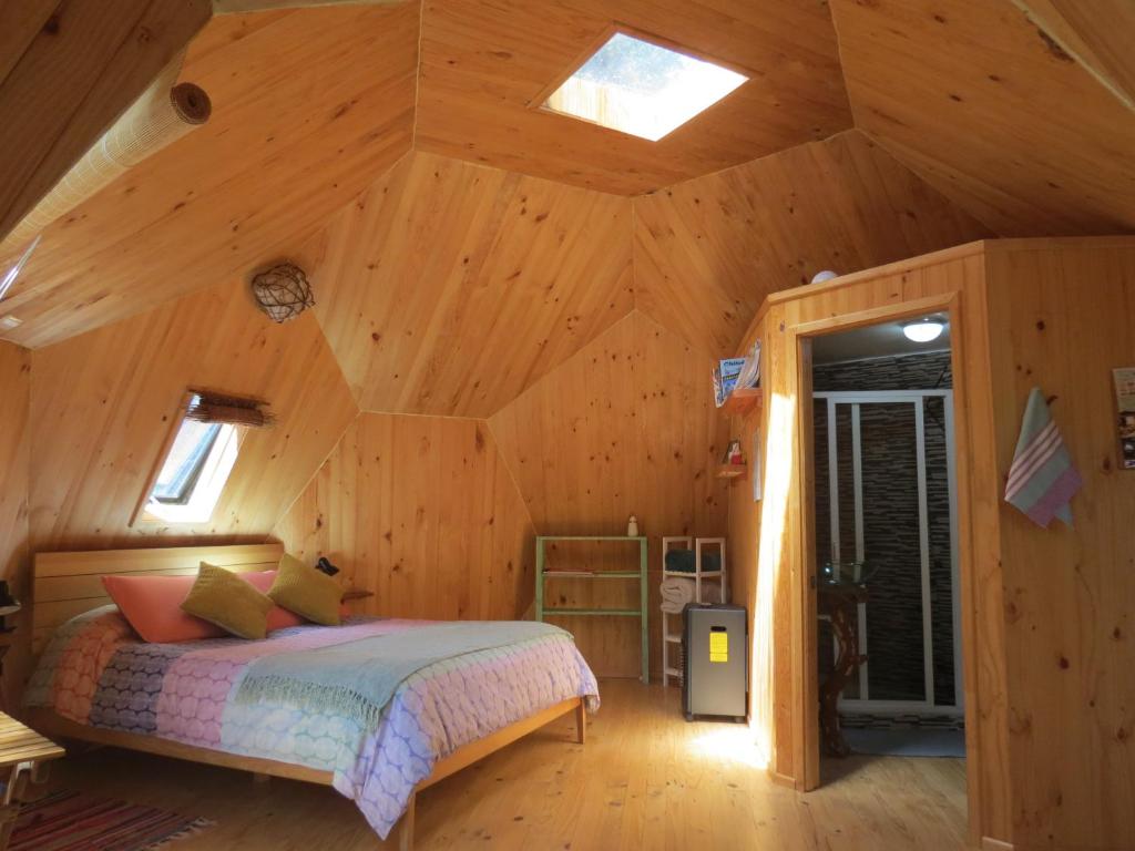拉恩塞纳达Lemunantu Domo Solar的小木屋内一间卧室,配有一张床