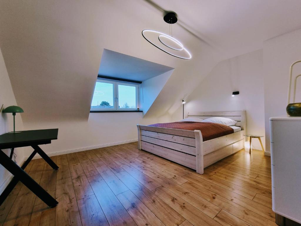 阿伦斯堡Hell & ruhig, 200m zur U-Bahn的一间卧室配有一张床、一张书桌和一个窗户。