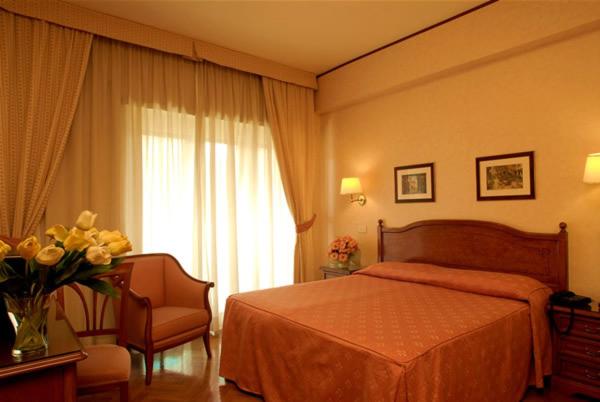 罗马桑皮耶特罗酒店的一间卧室,配有一张床和花瓶
