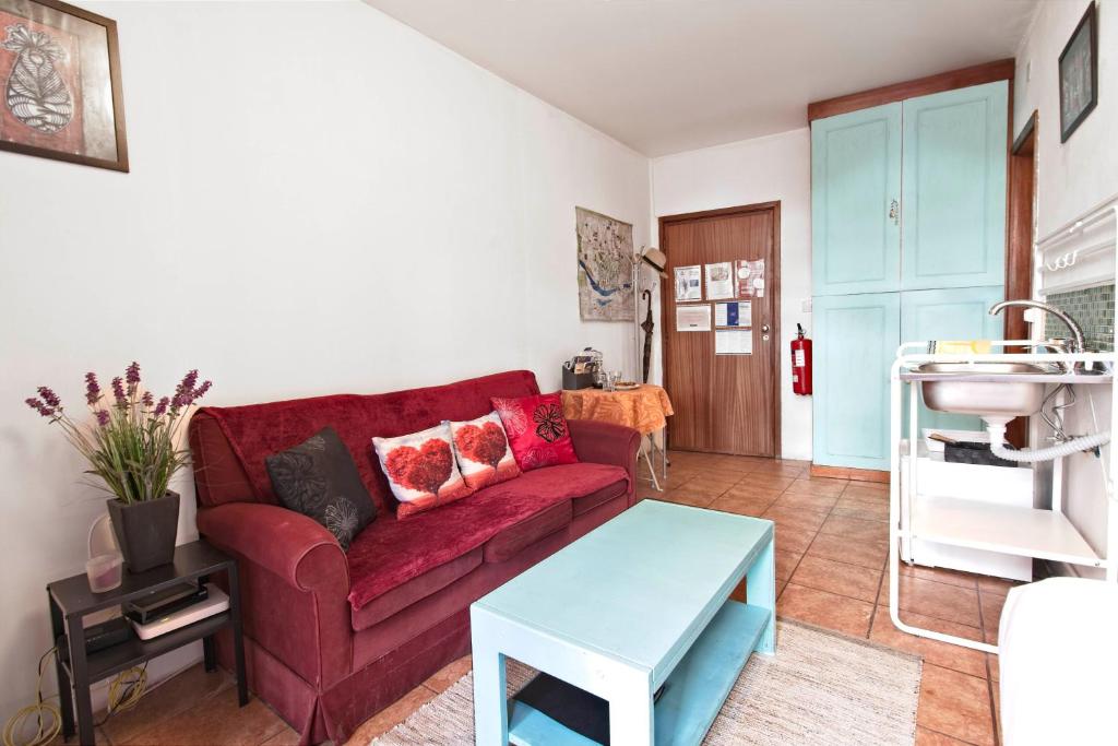 波尔图Ribeira Smart Suite的客厅配有红色的沙发和桌子