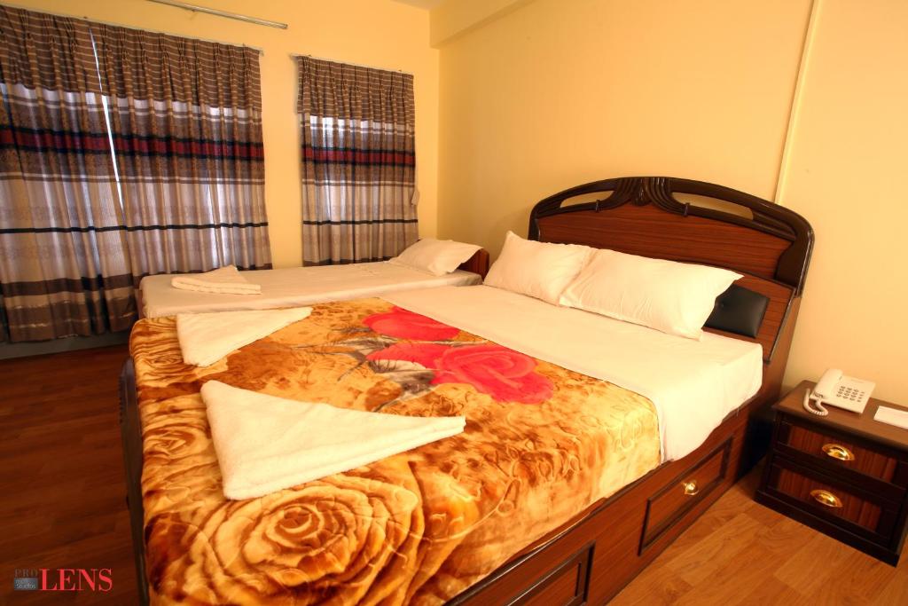 ToknaHotel Melungtse & Apartment的一间卧室配有两张带鲜花的床