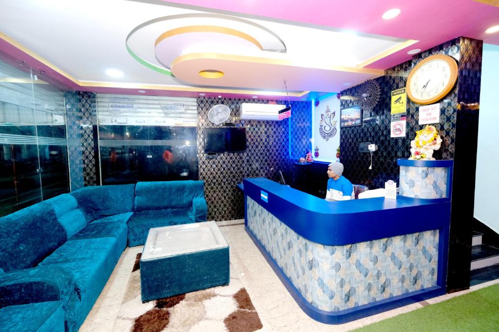 德奥加尔Hotel Krishna Paradise的大堂设有蓝色的沙发和酒吧