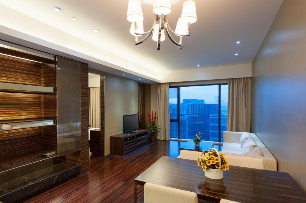 广州易成国际公寓广州琶洲保利世贸店的客厅配有吊灯和桌子