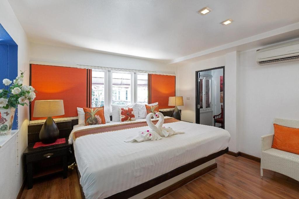 芭东海滩百佛生活公寓的卧室配有一张睡床,两只天鹅
