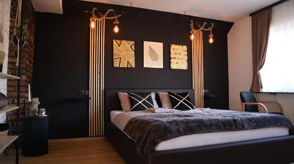 萨拉热窝Gondola Apartment的一间卧室配有一张黑色墙壁的床