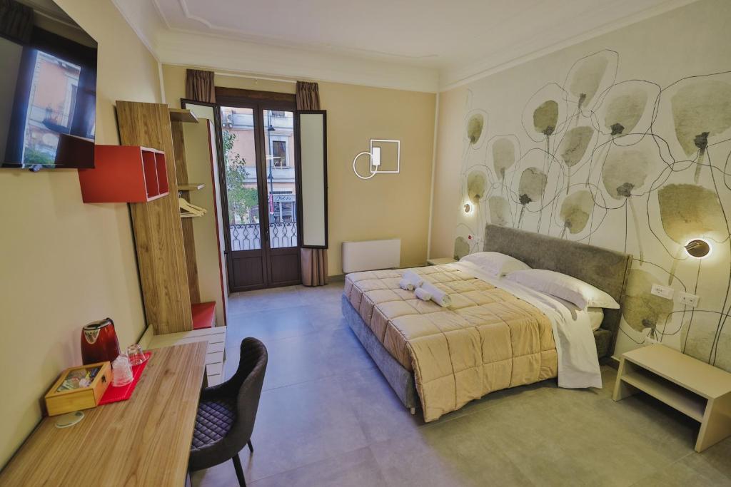 科森扎Brettia Guest Rooms的一间卧室配有一张床、一张书桌和一台电视。