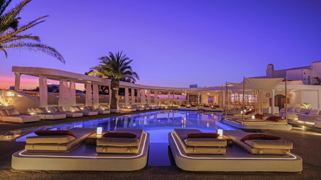 米克诺斯城安德罗尼哥斯酒店的酒店游泳池设有躺椅,酒店还设有一个度假村