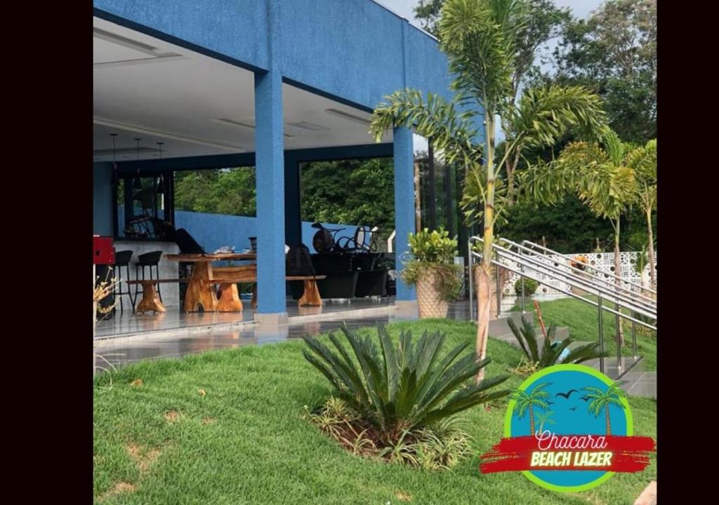 伊瓜苏Chacara Beach Lazer的一座蓝色的建筑,在院子里种着棕榈树