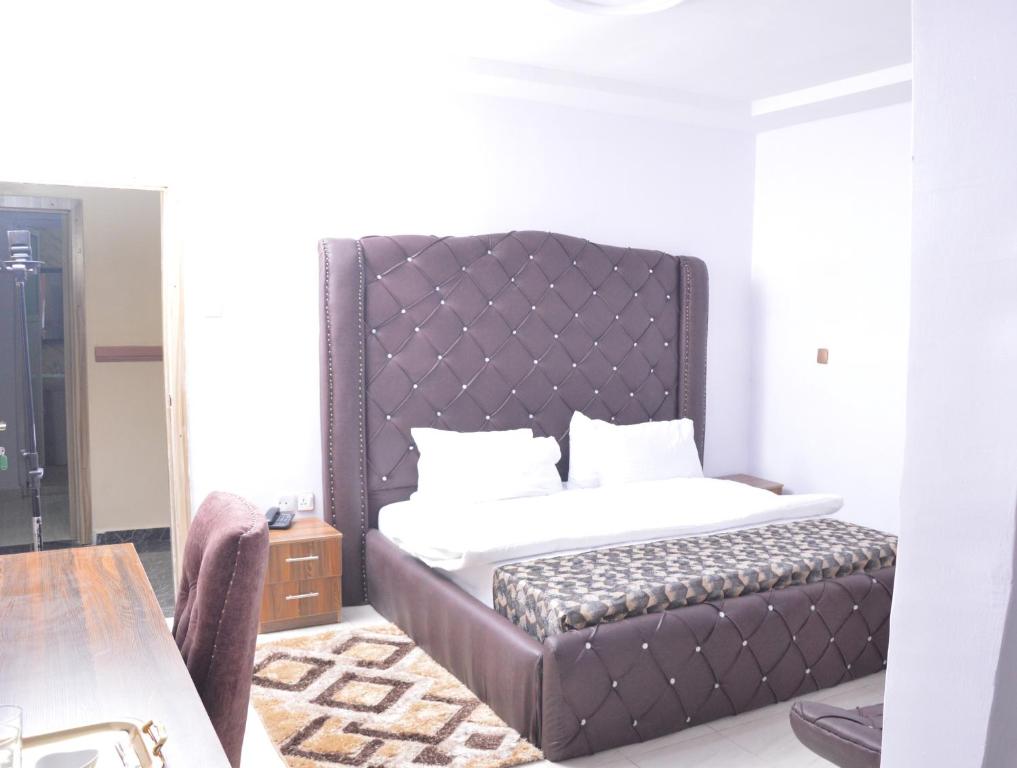 Oba IleAkure Airport Hotel的一间卧室配有一张带大床头板的床
