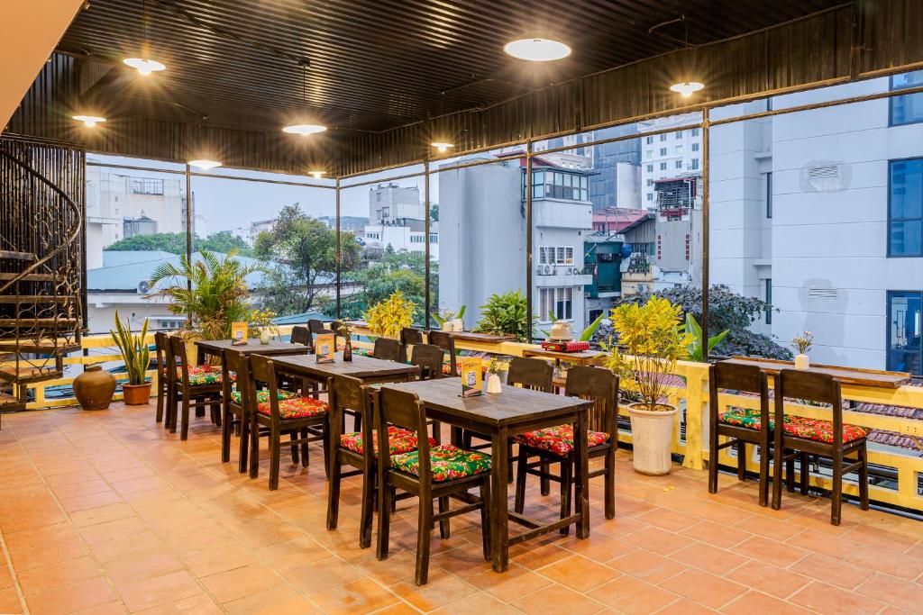 河内Hanoi Retro 80S Homestay的餐厅设有桌椅和大窗户。