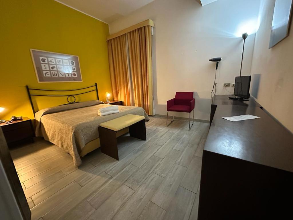 鲁巴诺勒卡兰德雷酒店的酒店客房,配有一张床和一张红色椅子