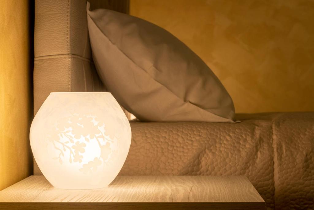 米兰Leader Apartment 3的白色的花瓶坐在带枕头的沙发上