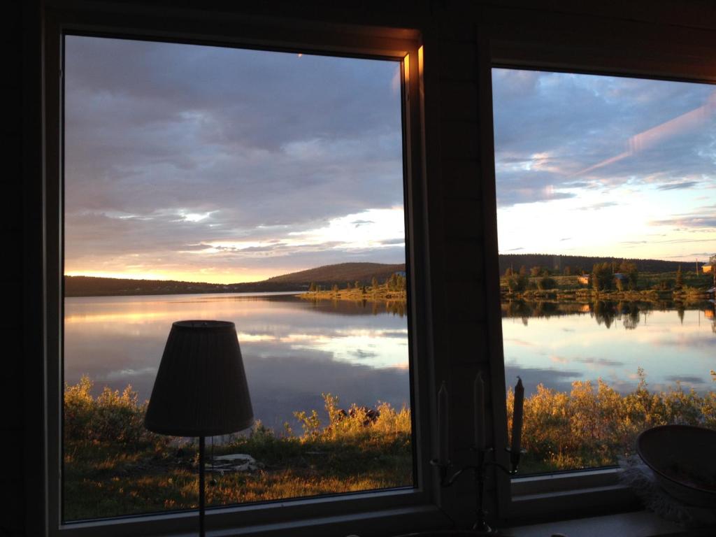 SkauloLakeside cottage in Lapland with great view的透过窗户透过灯可欣赏到湖景