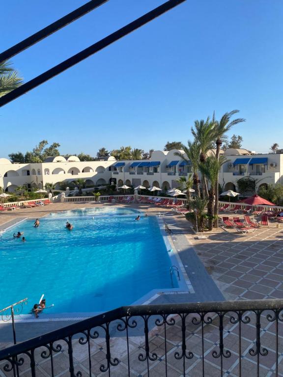 乌姆苏克Le Petit Palais Djerba & Spa的从度假村的阳台上可欣赏到游泳池的景色