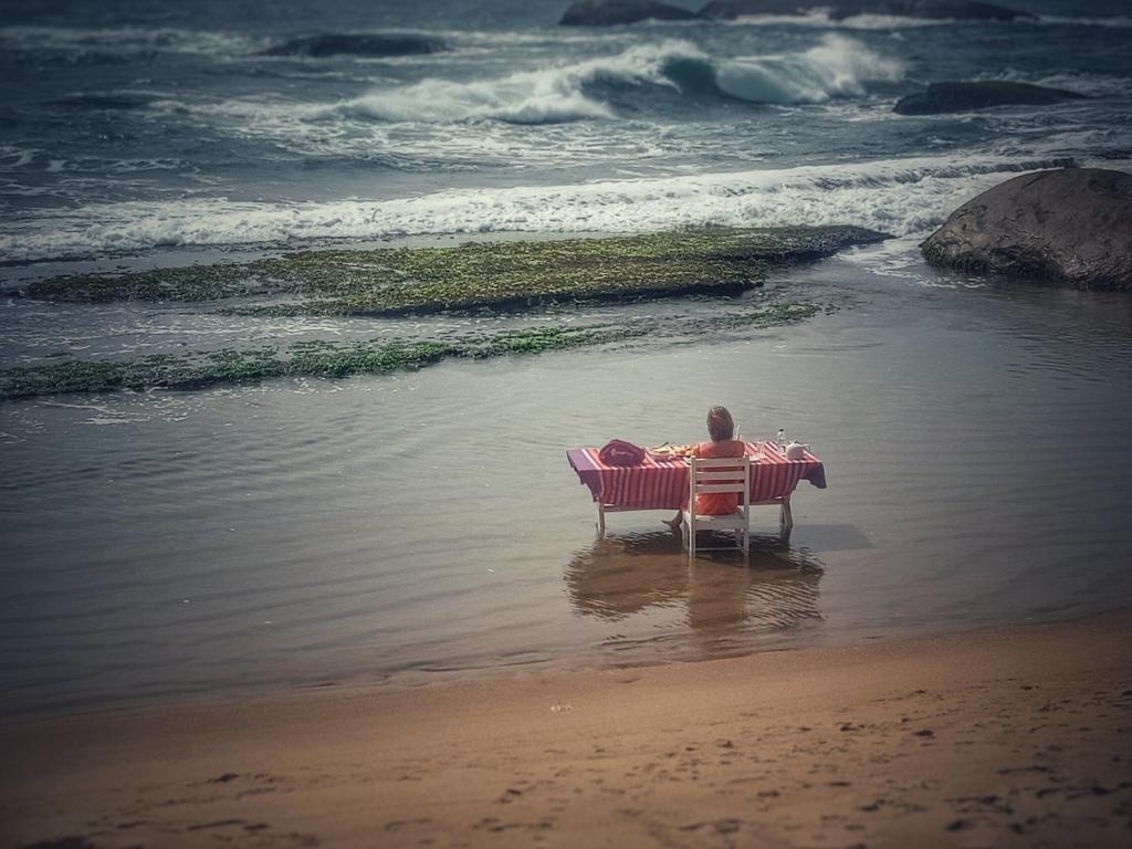 基林德Beach Bungalow Yala的坐在海滩长凳上的人