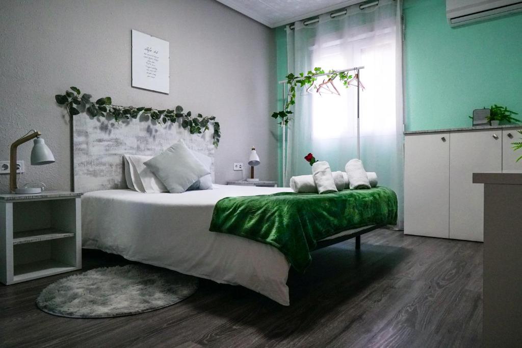 瓦伦西亚Bioparco Apartment的一间卧室配有一张带绿毯的大床