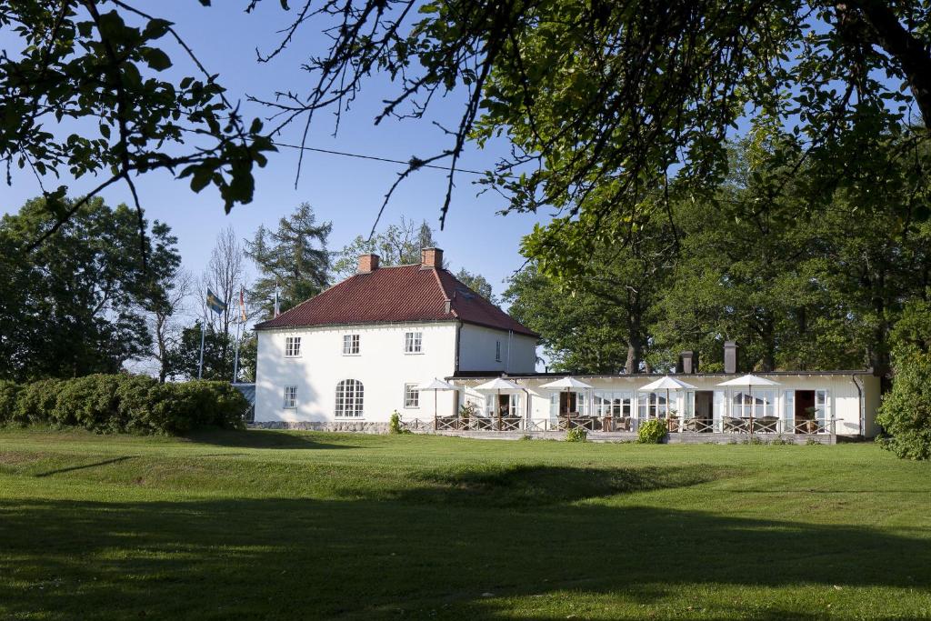 Stegeborg斯特格伯格花园酒店的绿色田野上红色屋顶的白色房子