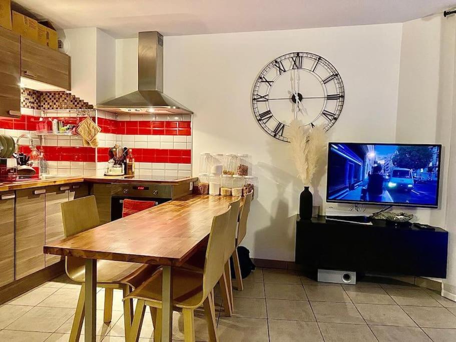 安锡Joli T2 dans Annecy的厨房配有桌子和墙上的大时钟