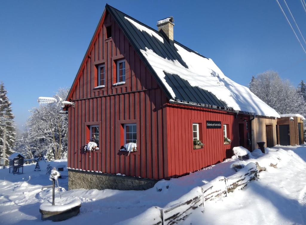 Nova Ves nad NisouChaloupka pod Kančí stezkou的屋顶上积雪的红色房子