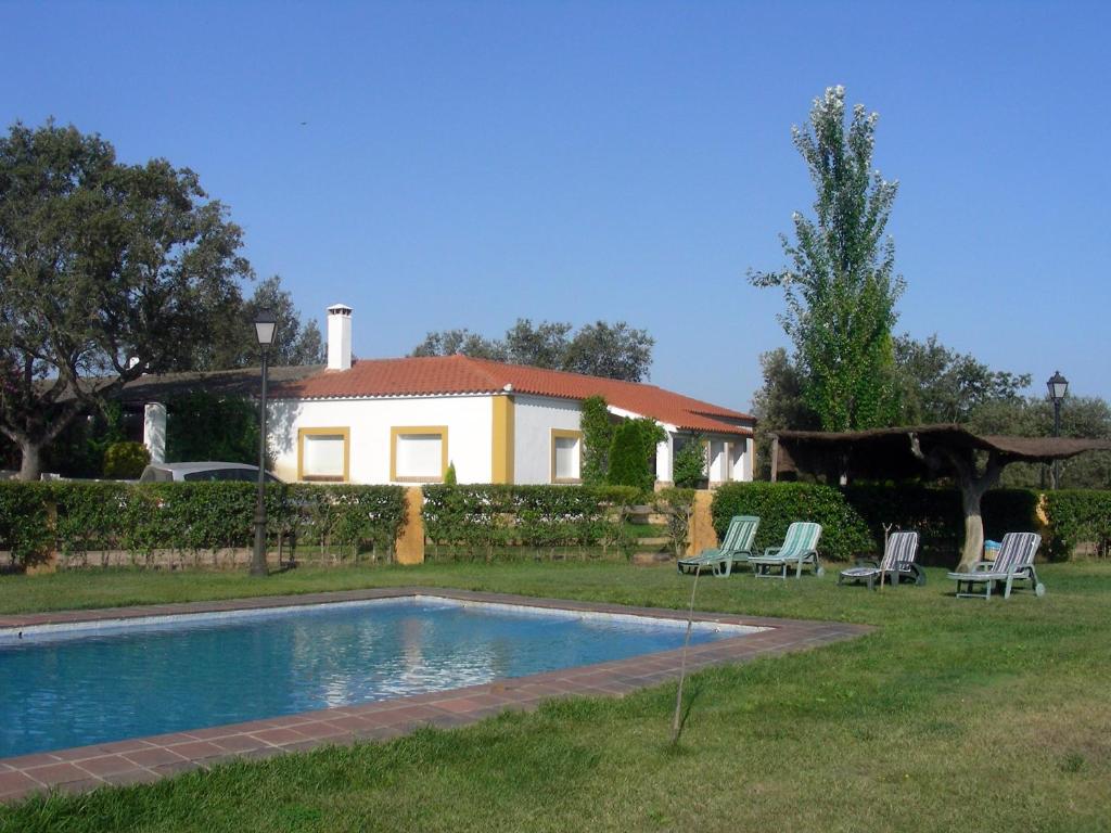 Herrera de AlcántaraFinca Dehesa Tres Riveros的庭院中带游泳池的房子