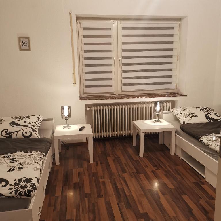 代特莫尔德Ferienunterkunft Sson的客房设有两张床、一个窗口和两张桌子