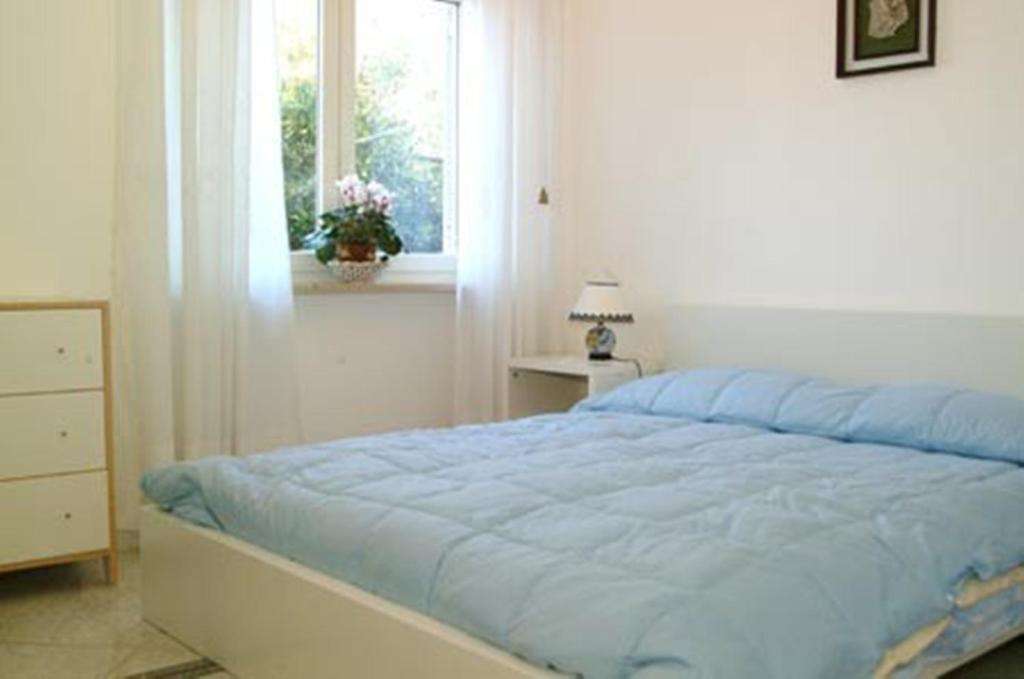 索伦托Villa Orchidea的一间卧室配有一张蓝色的床和窗户