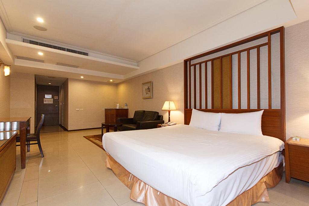 中和SLV旅馆集团 - 君迪馆的酒店客房设有一张白色大床和椅子