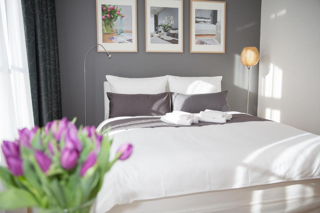 莱比锡一室公寓44号酒店的卧室配有白色的床和花瓶