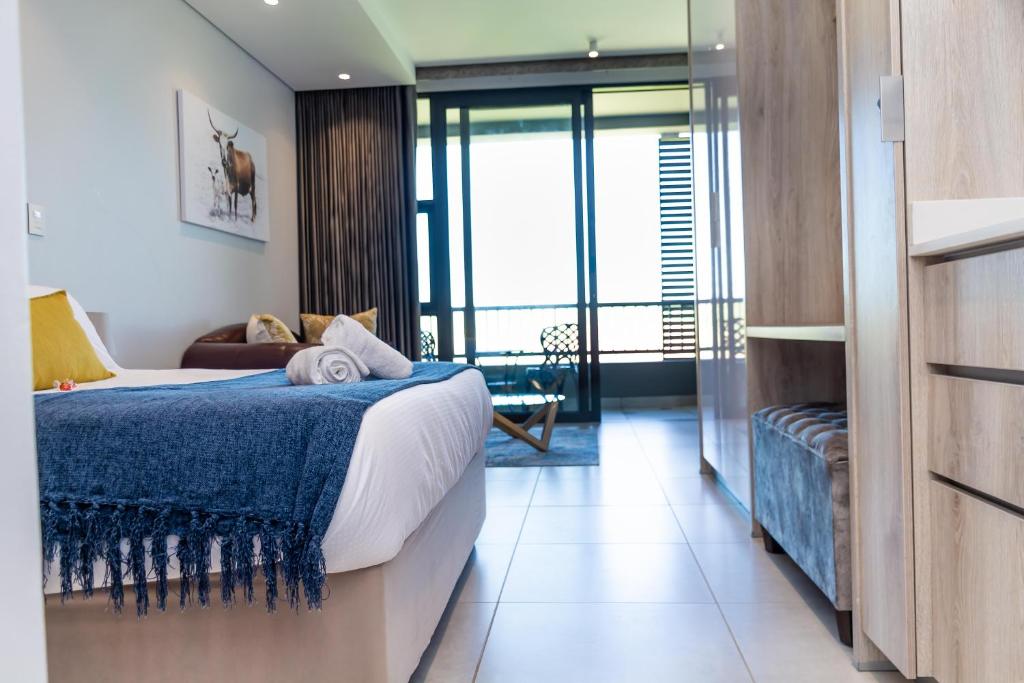巴利托Zimbali Lakes Boulevard Suites的酒店客房,配有一张带蓝色毯子的床