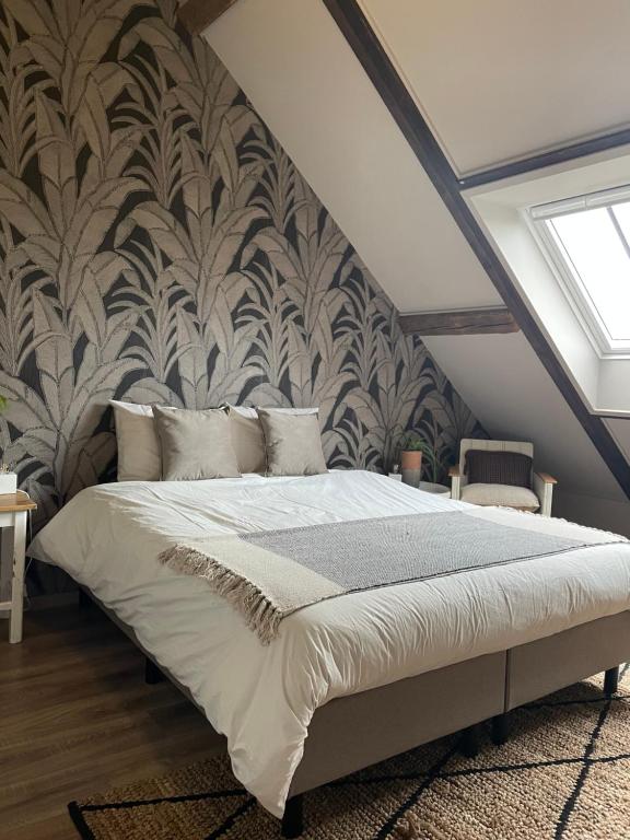 多德雷赫特De Zuileshoeve的一间卧室设有一张大床和墙壁