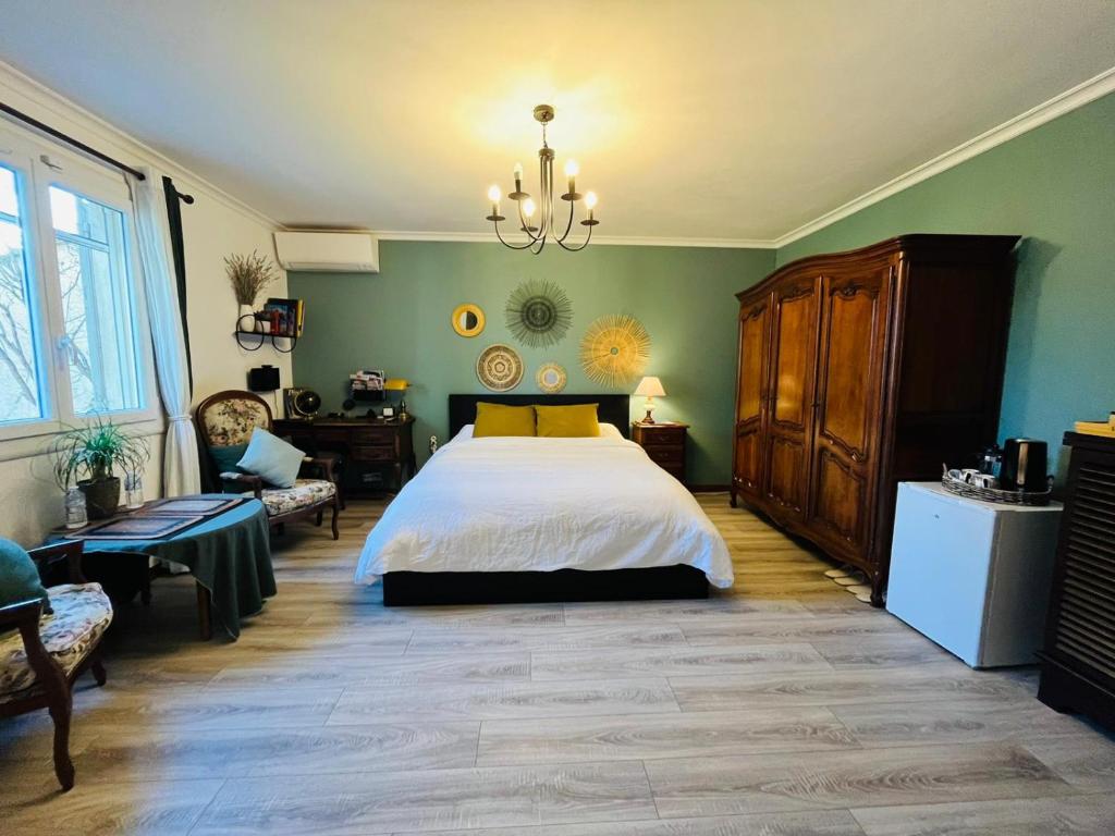 莫里埃莱阿维尼翁La Maison du Chemin des Prairies的一间卧室配有一张大床和一个吊灯。
