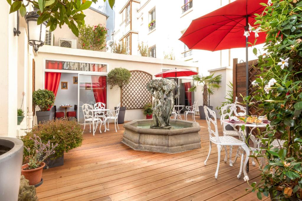 巴黎Agate Hôtel的庭院设有喷泉、桌椅和遮阳伞。