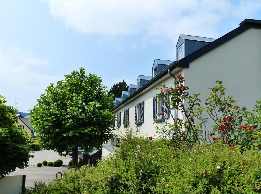 克莱沃马诺尔卡瑟斯莱的白色的建筑,有蓝色百叶窗和树木