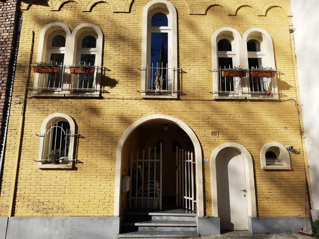 博尔赫隆Loft in Borgloon的黄色砖砌建筑,有三扇窗户和一扇门