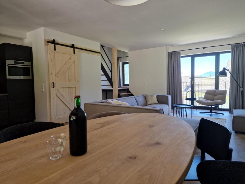 魏斯布里阿赫Weißbriach Lodge的客厅的木桌旁摆放着一瓶葡萄酒