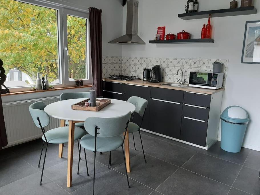 PosterholtVrijstaande recreatievilla met ruime omheinde tuin的厨房配有桌椅
