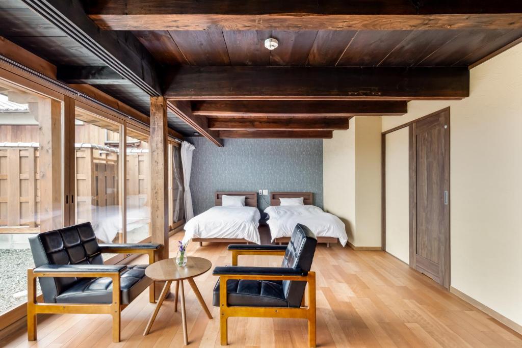 GojōSatsuki 的一间卧室配有一张床、两把椅子和一张桌子