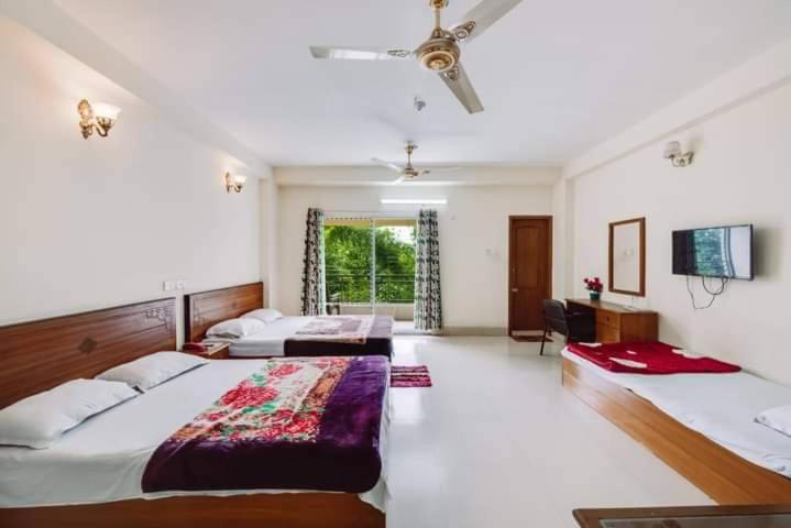 BāndarbanHill Crown Hotel & Resort的一间大卧室,配有两张床和电视