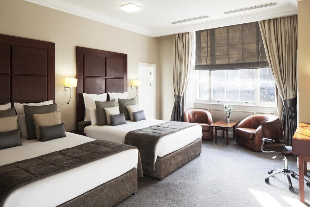 伦敦比彻姆农庄酒店的酒店客房,配有两张床和椅子