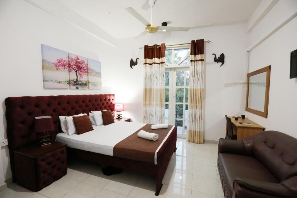 波隆纳鲁沃塞亚拉度假酒店的一间卧室配有一张大床和一张沙发