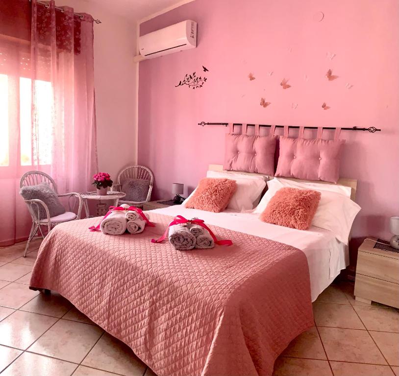 维拉普特祖Butterfly House的卧室配有一张带粉红色墙壁的大床