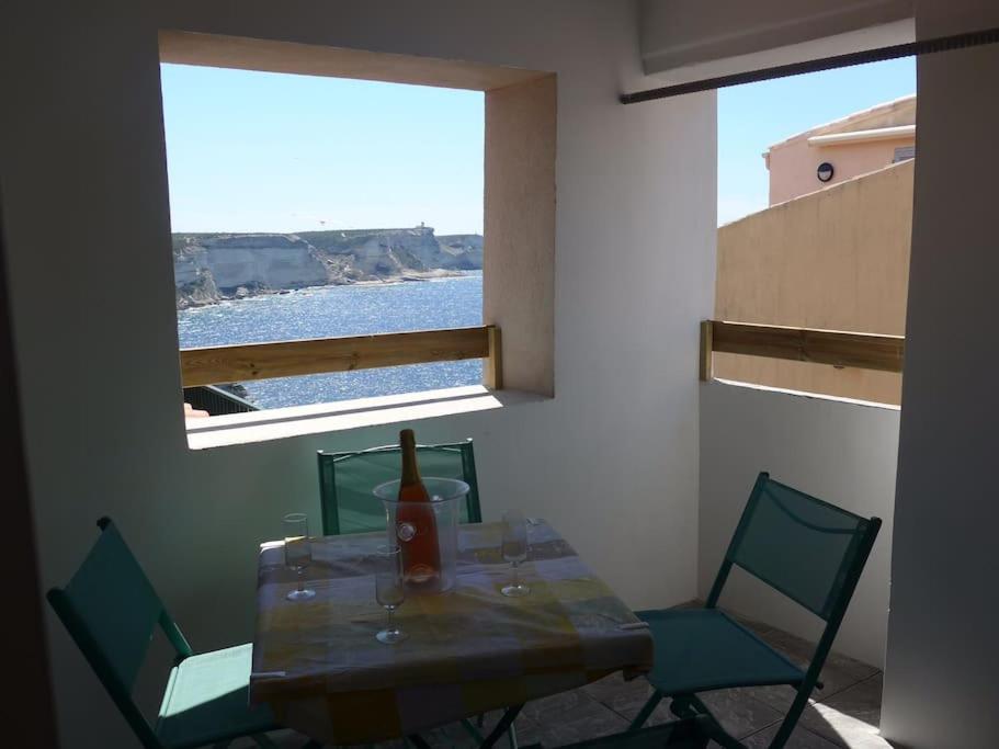 博尼法乔Duplex sur un fameux Grain de sable的餐桌、椅子和窗户