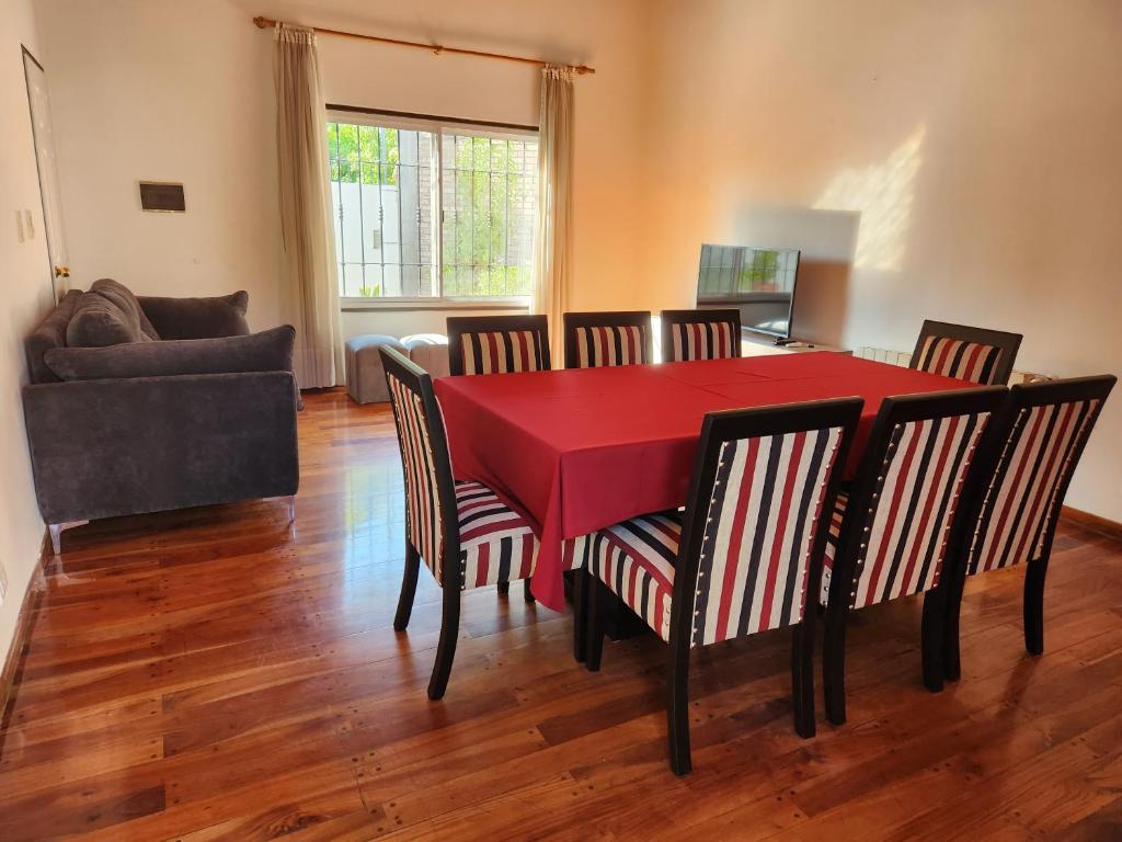 门多萨Casa DELUXE MALBEC , Barrio Privado, con cochera doble, jardín y churrasquera的一间用餐室,配有红色的桌子和椅子
