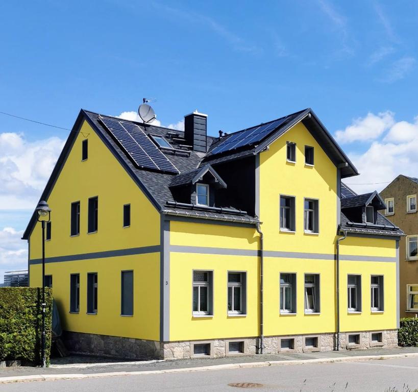 艾本施托克Fewo Klöppel Auersbergblick的黑色屋顶的黄色房子