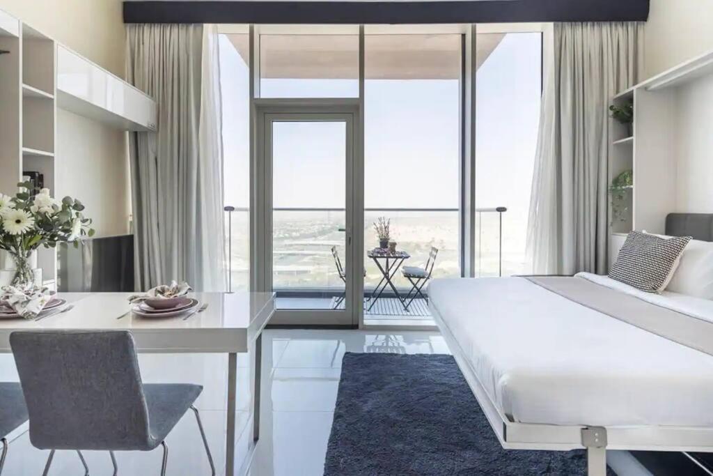 迪拜Miraclz Skyline Tower的卧室配有一张白色大床和一张餐桌