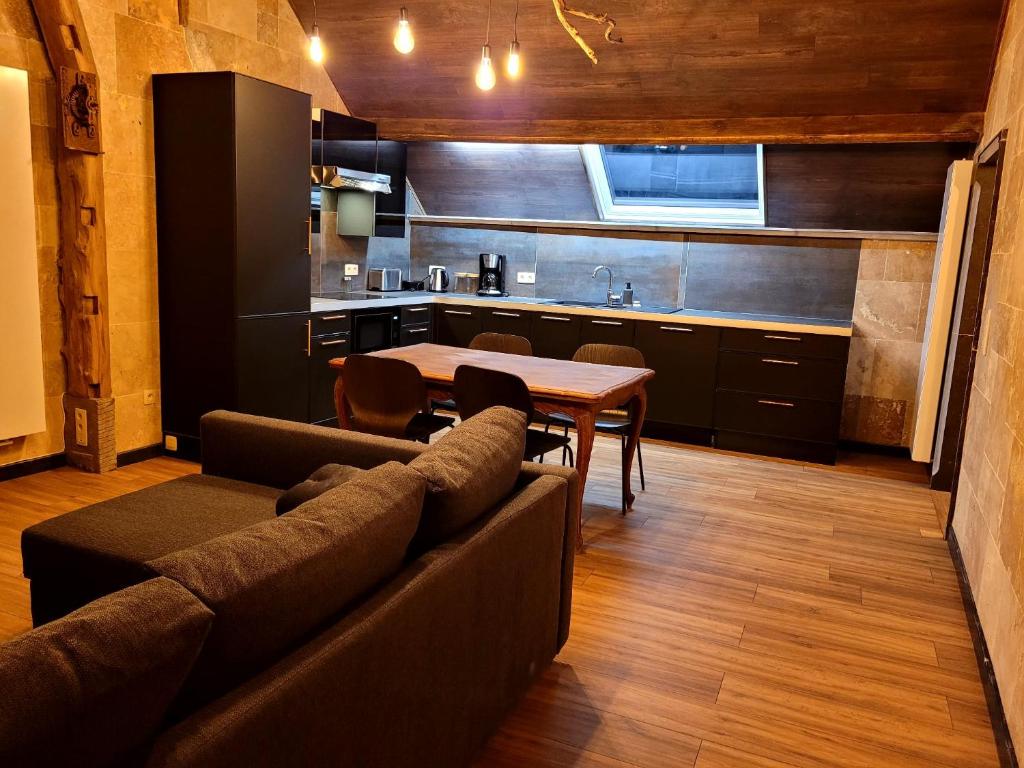 阿特Chez Claude appartement cozy climatisé pour 4 personnes tout confort的带沙发和桌子的客厅以及厨房。